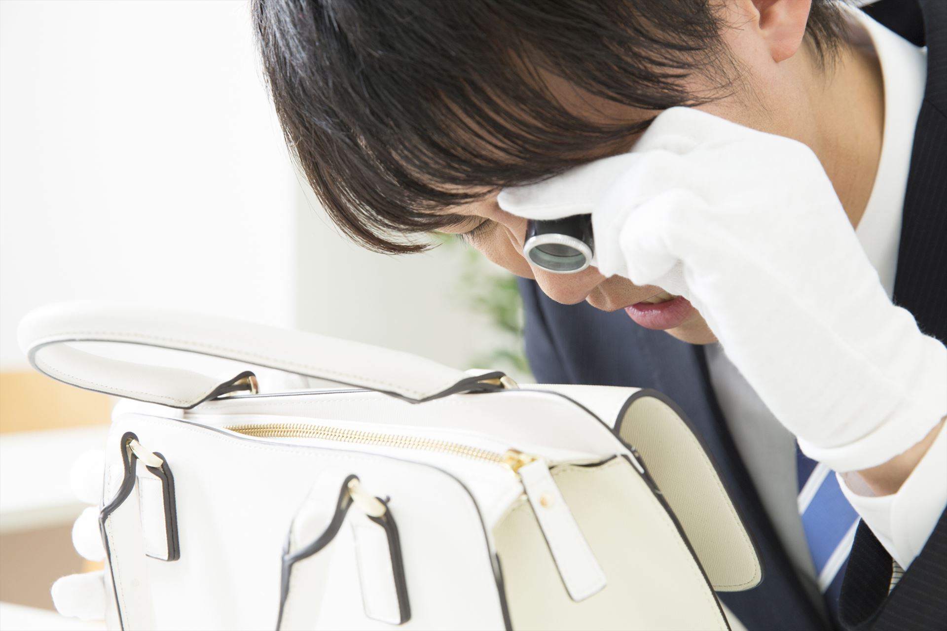 バッグに損傷がないか確認する鑑定士
